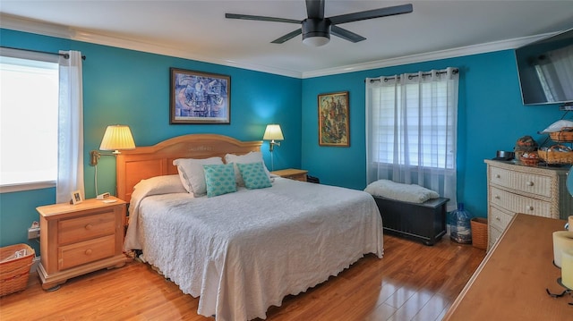 bedroom with ceiling fan, wood-type flooring, and ornamental molding