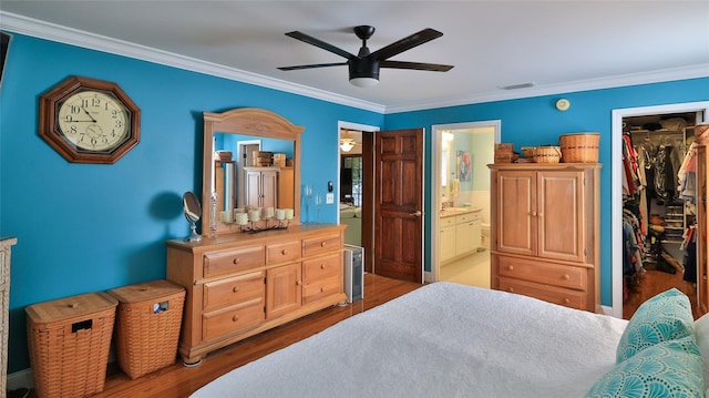 bedroom with ceiling fan, ensuite bathroom, light hardwood / wood-style floors, a walk in closet, and a closet