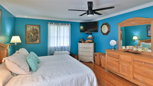 bedroom featuring hardwood / wood-style flooring, ceiling fan, and crown molding