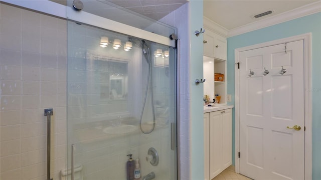 bathroom with a shower with door and crown molding