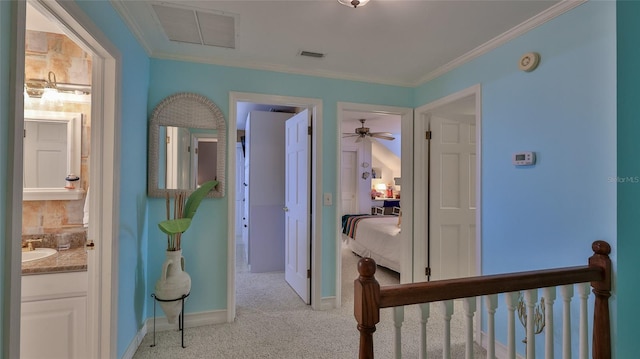 hall with light colored carpet, crown molding, and sink