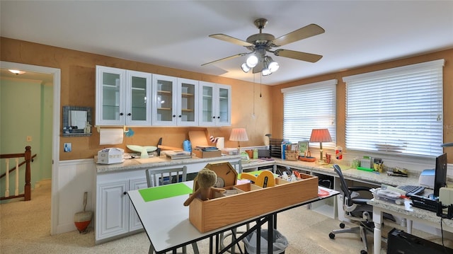 kitchen featuring light colored carpet, white cabinetry, and ceiling fan