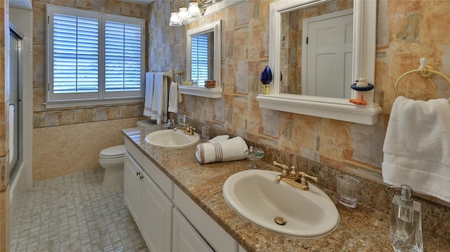 bathroom with tile patterned flooring, vanity, tile walls, and toilet