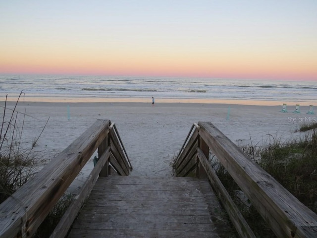 surrounding community featuring a beach view and a water view