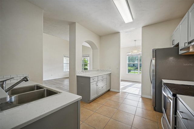 kitchen featuring pendant lighting, gray cabinetry, stainless steel range with electric cooktop, sink, and light hardwood / wood-style floors