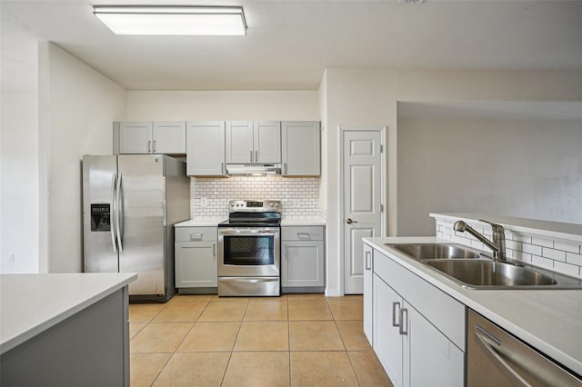 kitchen featuring sink, gray cabinets, decorative backsplash, light tile patterned floors, and appliances with stainless steel finishes