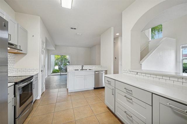 kitchen featuring decorative backsplash, stainless steel appliances, and sink