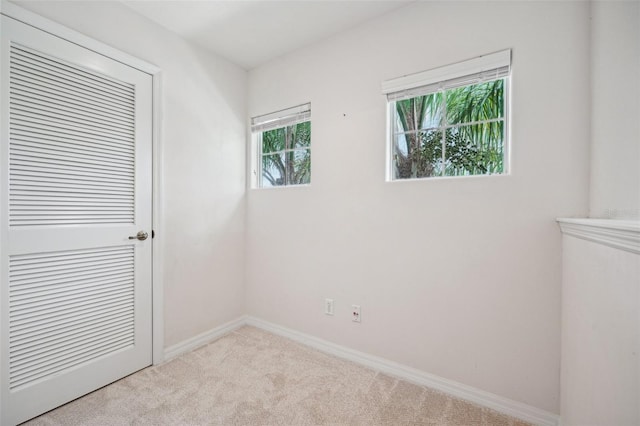 unfurnished room featuring light colored carpet