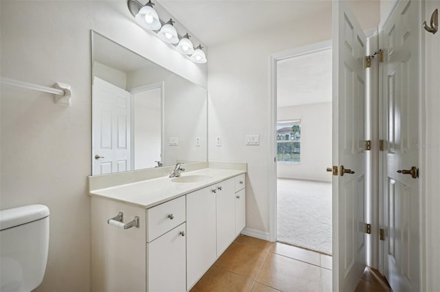 bathroom with tile patterned flooring, vanity, and toilet