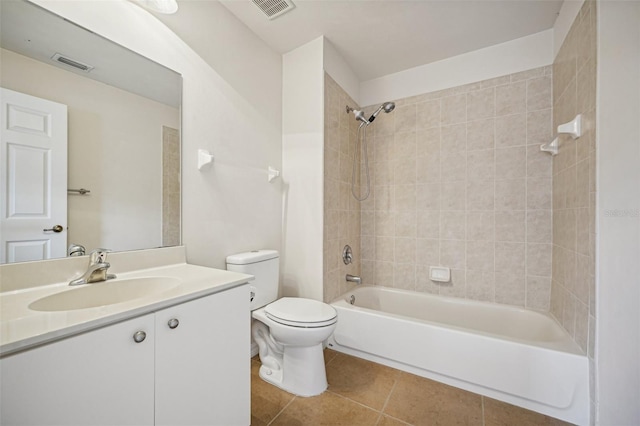 full bathroom with vanity, tile patterned flooring, tiled shower / bath, and toilet