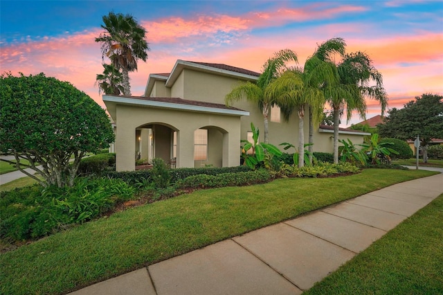 mediterranean / spanish house featuring a yard