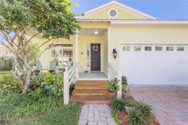 doorway to property featuring covered porch and a garage