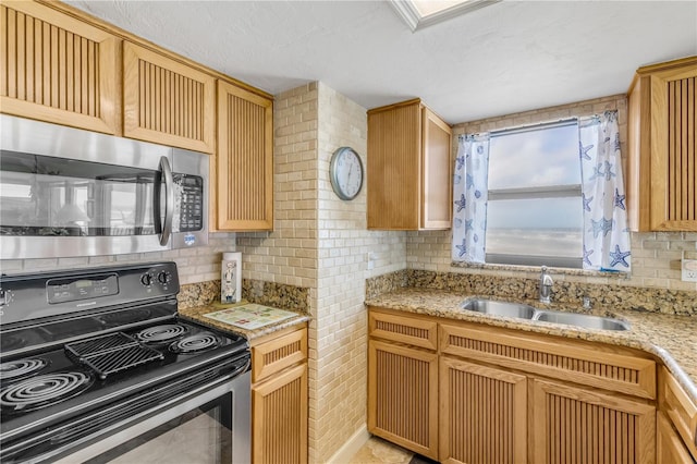 kitchen featuring sink, tasteful backsplash, light stone counters, range with electric stovetop, and a textured ceiling