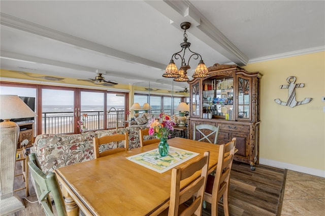 dining area with hardwood / wood-style floors, ceiling fan with notable chandelier, ornamental molding, a water view, and beam ceiling