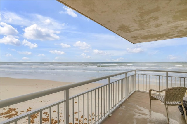 balcony featuring a water view and a view of the beach