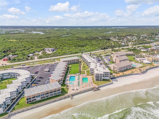 birds eye view of property with a water view and a view of the beach