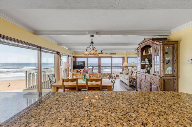 4811 Saxon Dr Unit C102, New Smyrna Beach, FL 32169 - dining room featuring crown molding, beamed ceiling, a chandelier, and a healthy amount of sunlight