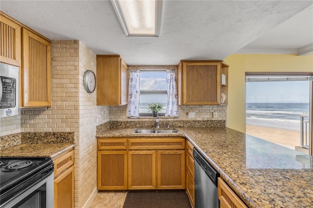 4811 Saxon Dr Unit C102, New Smyrna Beach, FL 32169 - kitchen featuring appliances with stainless steel finishes, light stone counters, a sink, a textured ceiling, and decorative backsplash