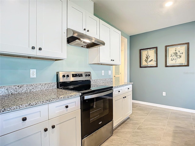 kitchen with light tile patterned floors, light stone counters, white cabinetry, and electric stove