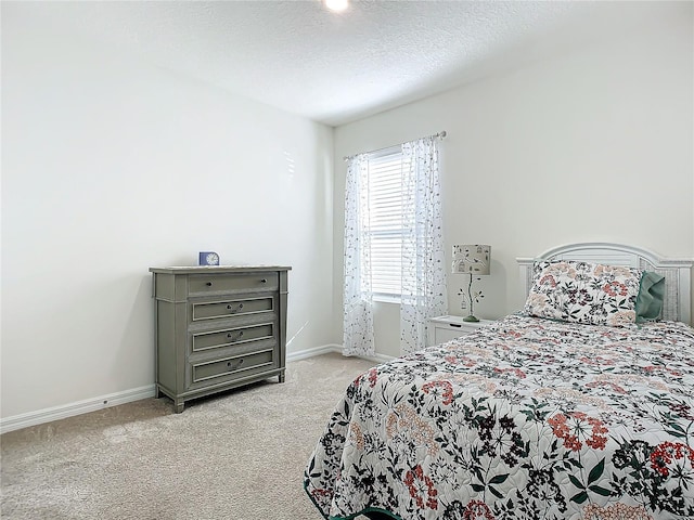 bedroom featuring a textured ceiling and light colored carpet