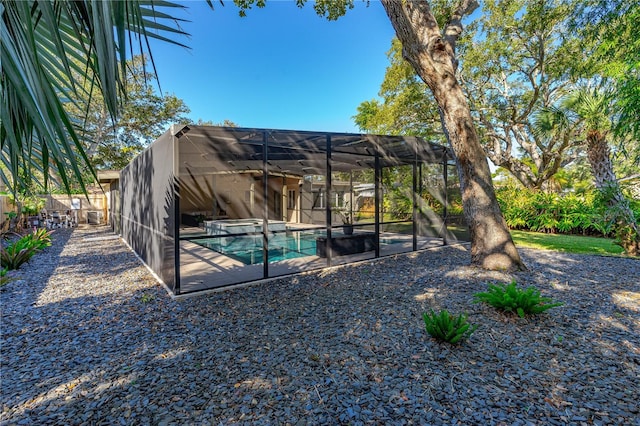 view of yard with a fenced in pool and glass enclosure