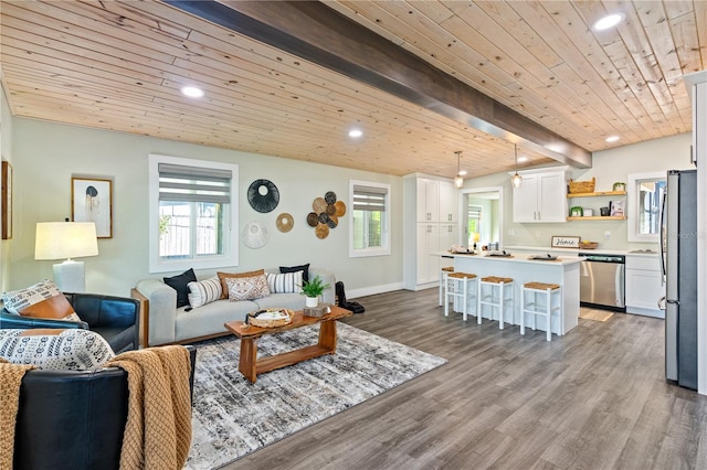 living room featuring beam ceiling, a wealth of natural light, light hardwood / wood-style flooring, and wooden ceiling