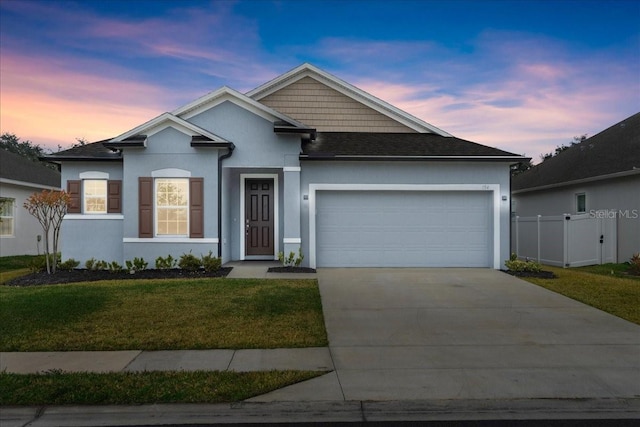 view of front of home with a garage and a yard