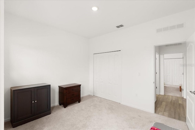 unfurnished bedroom featuring light colored carpet and a closet