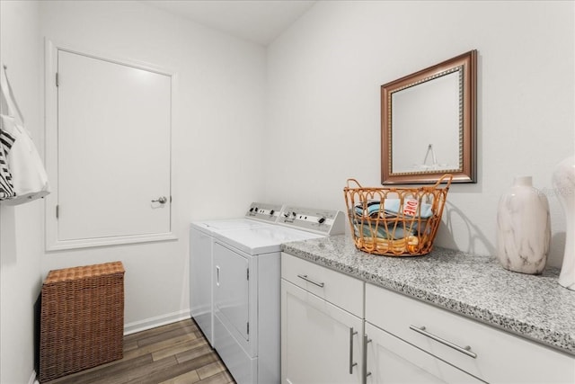 washroom featuring washer and dryer, dark hardwood / wood-style flooring, and cabinets