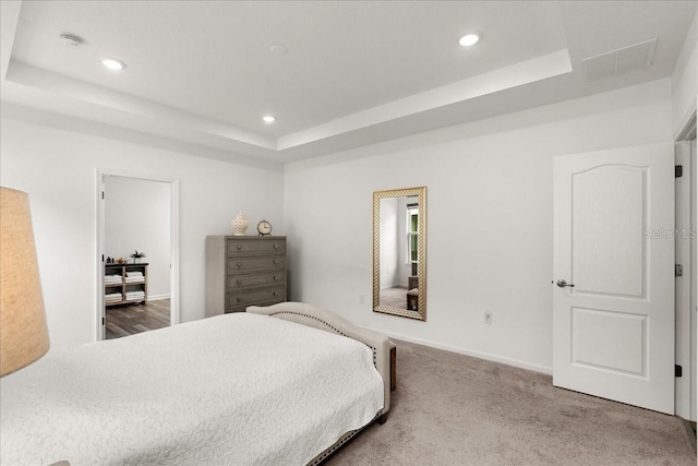 bedroom with carpet and a tray ceiling