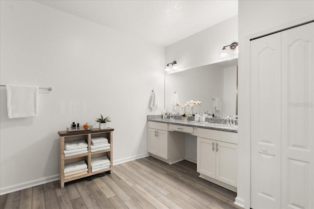 bathroom with a textured ceiling, vanity, and hardwood / wood-style flooring