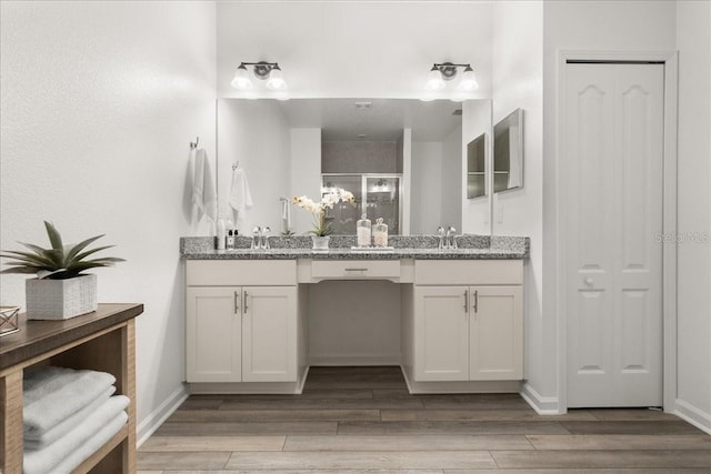 bathroom with wood-type flooring, vanity, and an enclosed shower