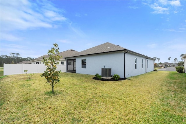 rear view of house with a yard and central AC unit