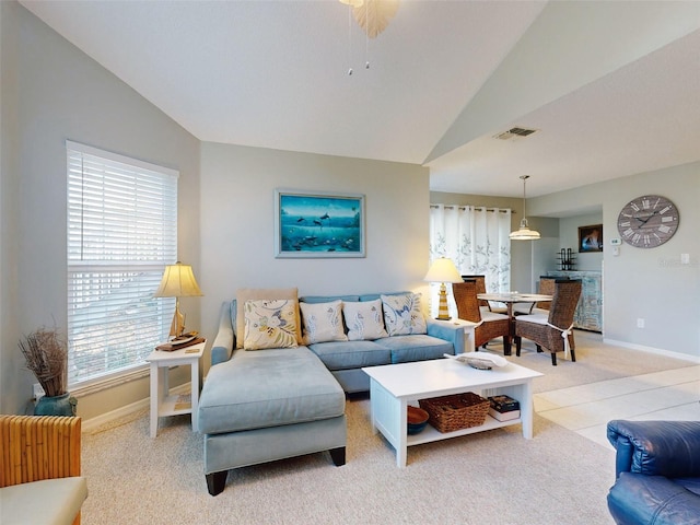 living area with lofted ceiling, baseboards, visible vents, and light colored carpet