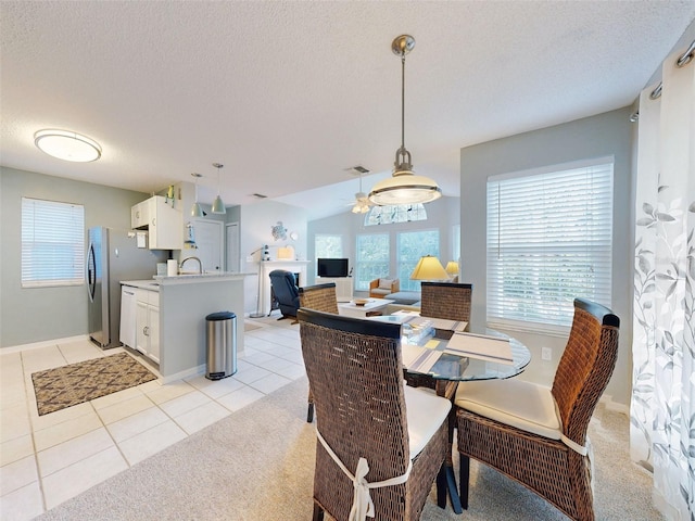 dining area featuring visible vents, light colored carpet, a textured ceiling, and light tile patterned flooring