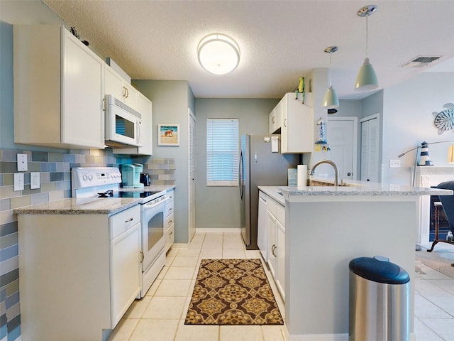 kitchen with light tile patterned flooring, white appliances, white cabinetry, visible vents, and tasteful backsplash