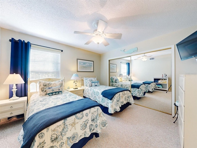 bedroom with visible vents, a ceiling fan, carpet, a textured ceiling, and a closet