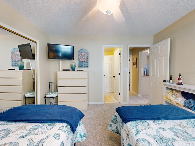 carpeted bedroom featuring a textured ceiling, a ceiling fan, and baseboards