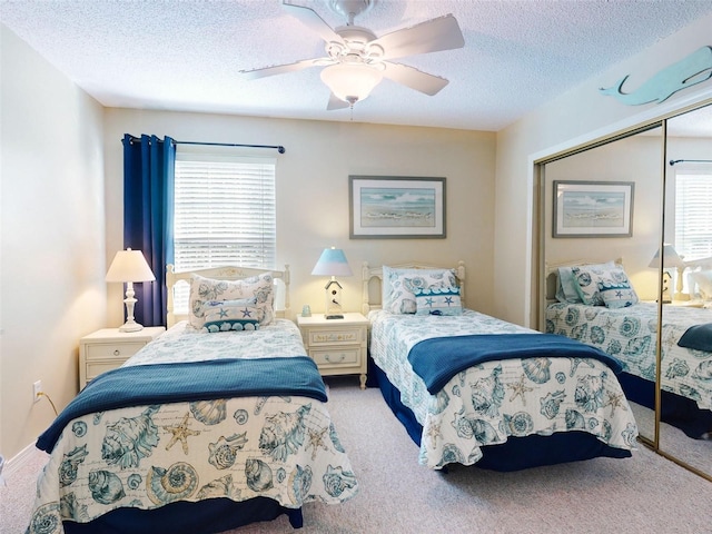 bedroom featuring a textured ceiling, multiple windows, a closet, and carpet