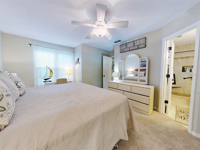 bedroom featuring a ceiling fan, visible vents, light carpet, and ensuite bathroom