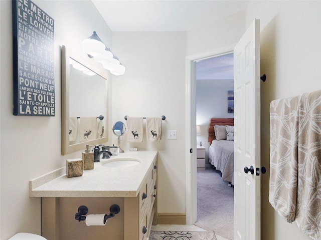 ensuite bathroom featuring ensuite bathroom, vanity, and baseboards