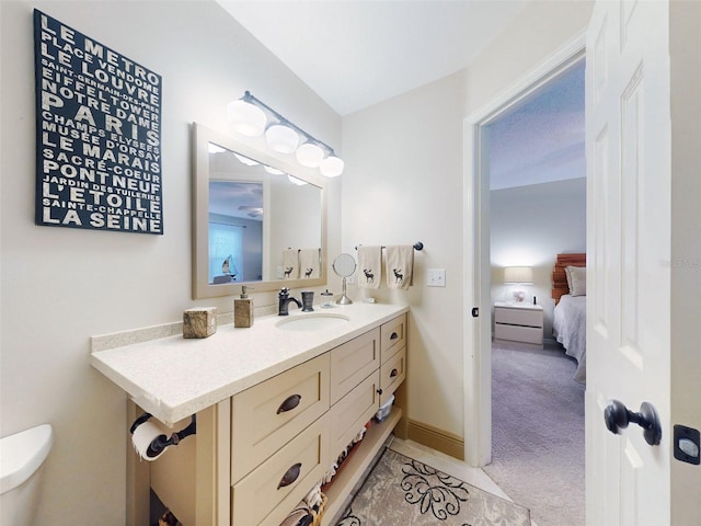 bathroom with toilet, vanity, and baseboards