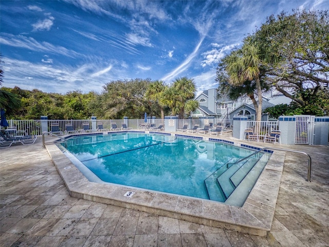 community pool featuring a patio area and fence