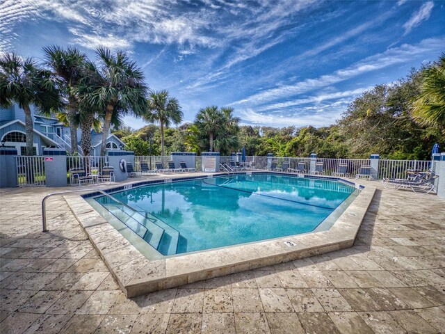 pool with fence and a patio