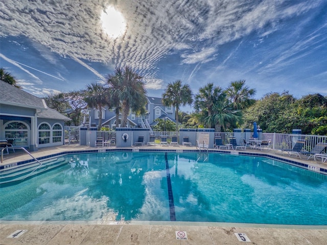 pool with fence and a patio