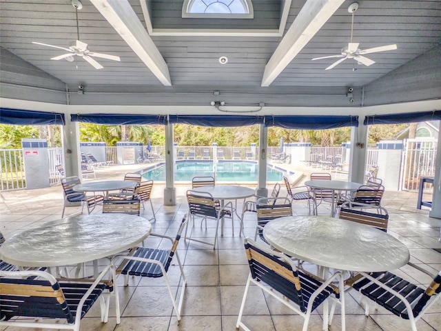 view of patio / terrace featuring outdoor dining space, fence, a community pool, and ceiling fan