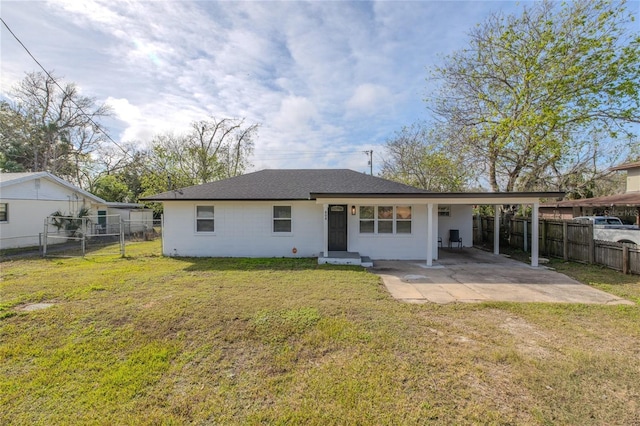 back of property featuring a carport and a lawn