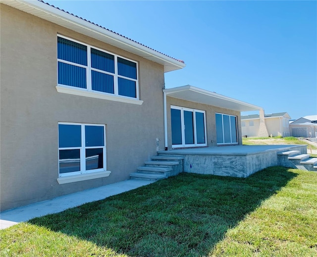 rear view of house featuring a yard