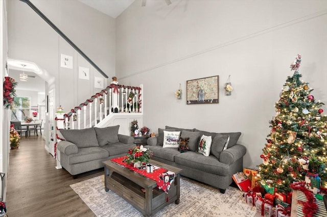 living room with hardwood / wood-style flooring and a towering ceiling