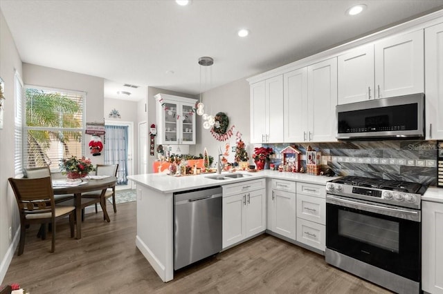 kitchen featuring white cabinets, light hardwood / wood-style floors, sink, and stainless steel appliances